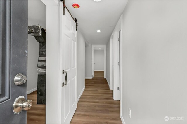 hall featuring hardwood / wood-style floors and a barn door