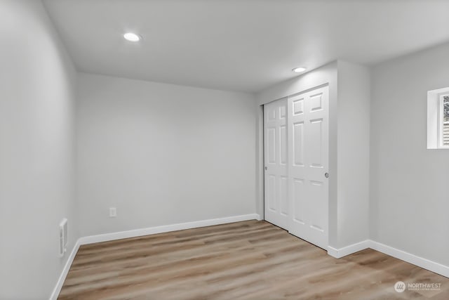 unfurnished bedroom featuring a closet and hardwood / wood-style floors