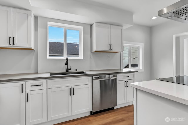 kitchen with dishwasher, light hardwood / wood-style floors, white cabinetry, sink, and wall chimney range hood