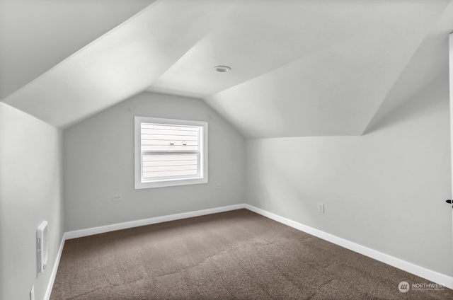 additional living space with carpet floors and vaulted ceiling