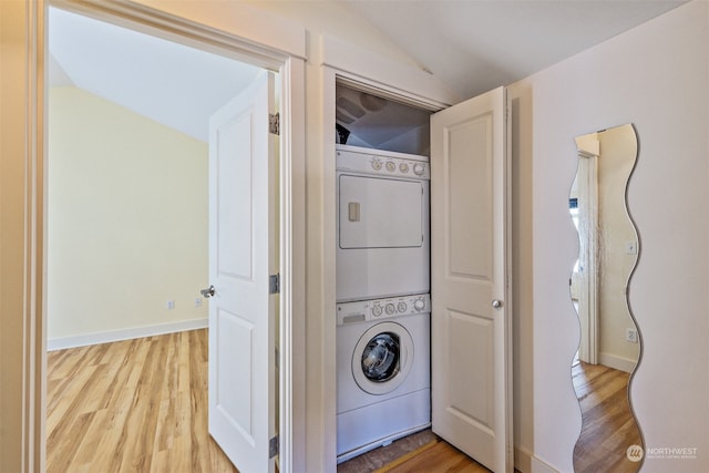 laundry area featuring light wood-type flooring and stacked washer / dryer