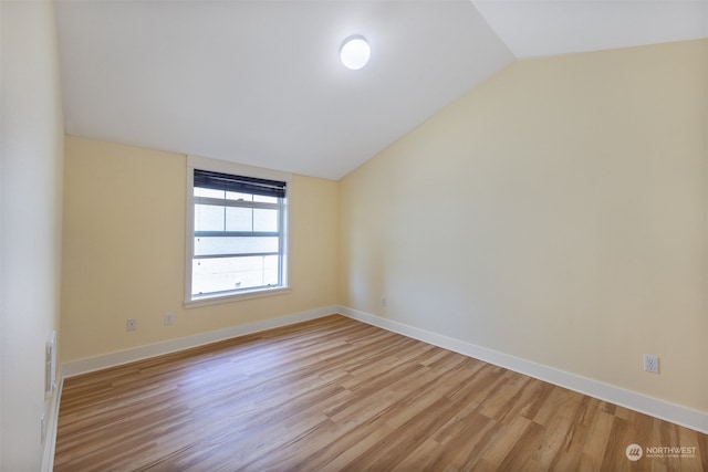 unfurnished room with light hardwood / wood-style floors and lofted ceiling