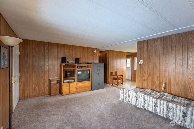 unfurnished living room with wood walls and light colored carpet