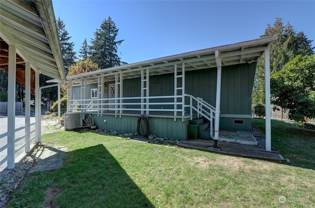 back of property with cooling unit and a yard