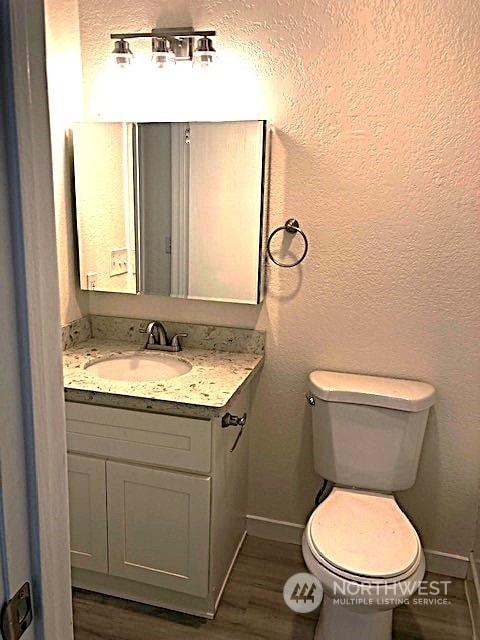 12602 NE 118th St, Kirkland, WA 98034 - half bath featuring baseboards, toilet, wood finished floors, vanity, and a textured wall