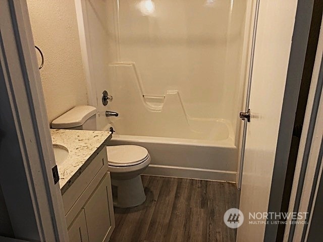 12602 NE 118th St, Kirkland, WA 98034 - bathroom with toilet, vanity, wood finished floors, washtub / shower combination, and a textured wall