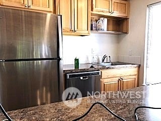 kitchen with dark stone countertops, sink, and stainless steel appliances