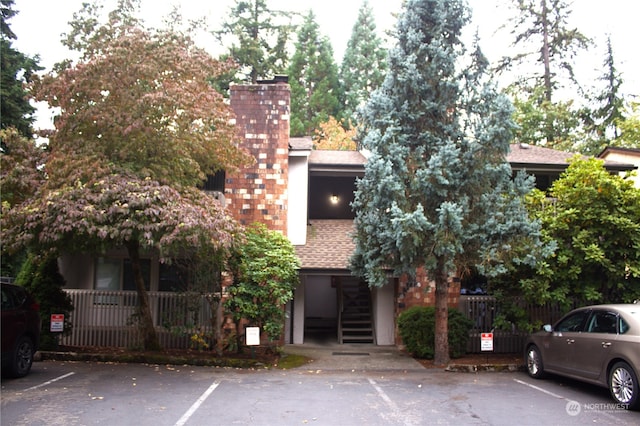 12602 NE 118th St, Kirkland, WA 98034 - view of building exterior featuring uncovered parking, stairway, and fence