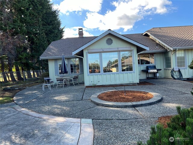 580 N Dunlap Ave, Sequim, WA 98382 - back of property with a chimney, fence, board and batten siding, a patio area, and roof with shingles