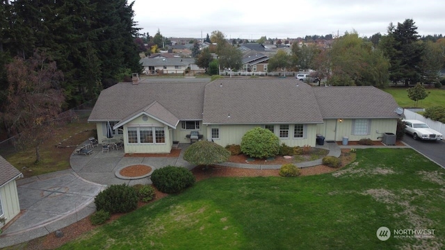 view of front of house with central AC unit and a front lawn