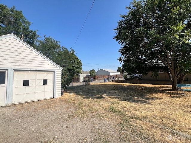 view of yard featuring an outdoor structure and a garage