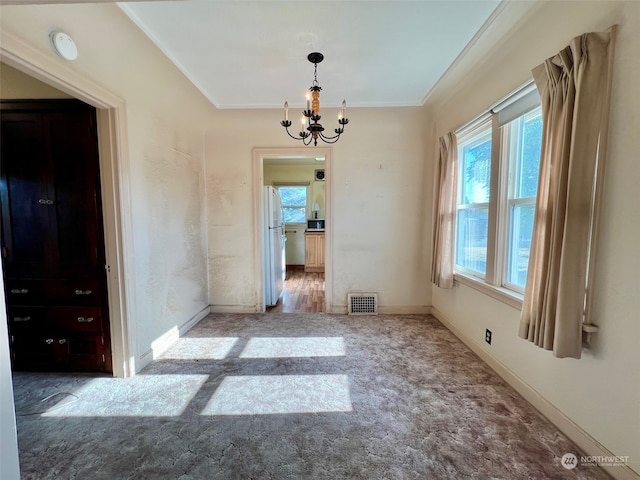 unfurnished dining area featuring ornamental molding, hardwood / wood-style flooring, and a chandelier