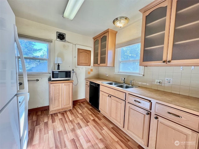 kitchen with black dishwasher, tasteful backsplash, sink, light hardwood / wood-style floors, and light brown cabinets