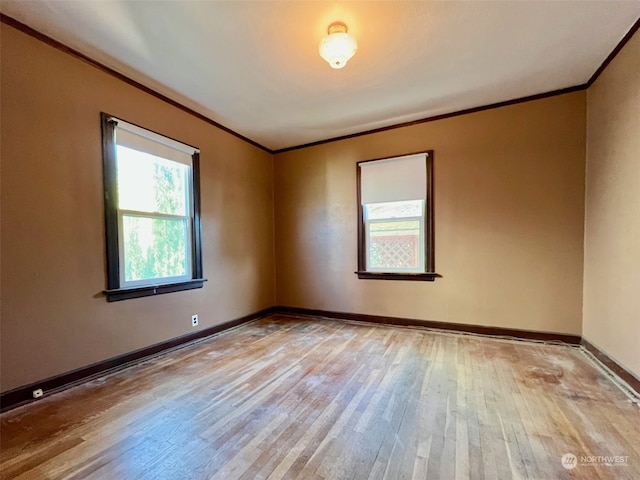 empty room featuring crown molding and light hardwood / wood-style flooring