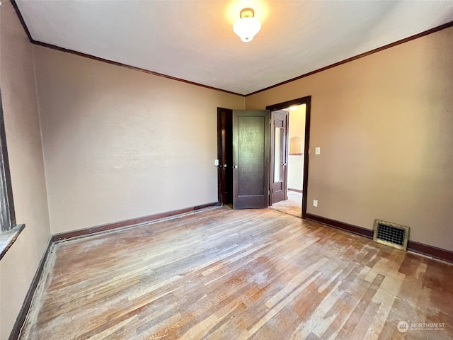 spare room featuring light hardwood / wood-style flooring and crown molding