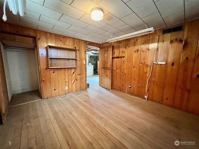 interior space with light hardwood / wood-style flooring and wood walls