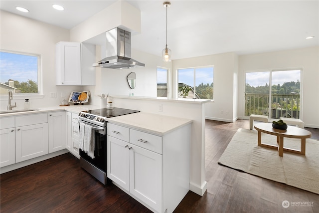 kitchen with stainless steel electric range oven, dark wood-type flooring, a wealth of natural light, and wall chimney exhaust hood