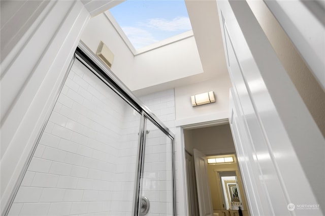 interior space featuring a shower with door and a skylight