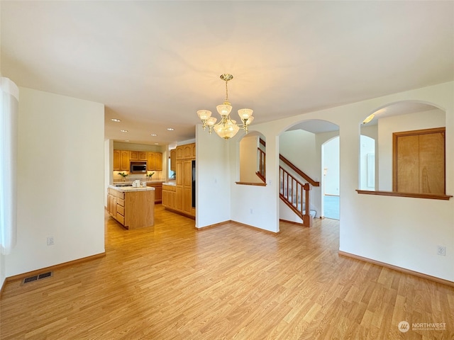 interior space featuring light wood-type flooring and a notable chandelier