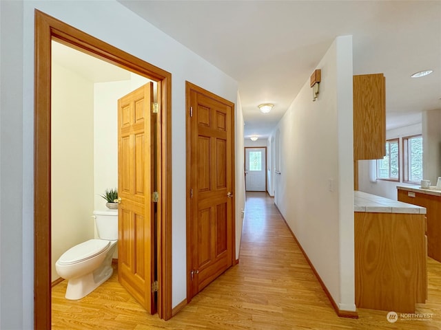 hallway with light hardwood / wood-style floors