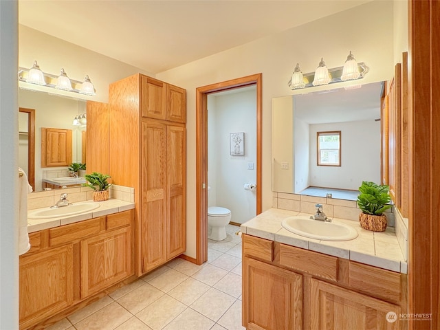 bathroom with toilet, vanity, and tile patterned floors