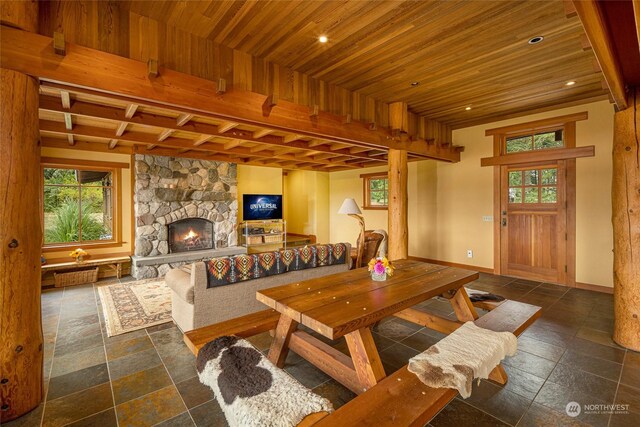 living room with wooden ceiling and a stone fireplace