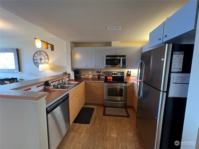 kitchen featuring appliances with stainless steel finishes, sink, and kitchen peninsula