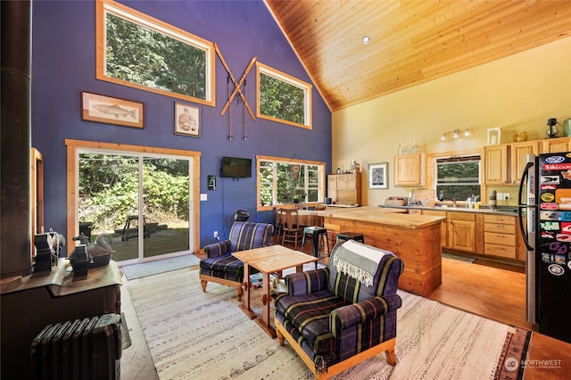 living room featuring wooden ceiling, high vaulted ceiling, and sink