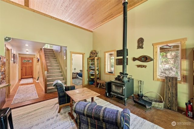 sitting room with wood ceiling, high vaulted ceiling, and a wood stove