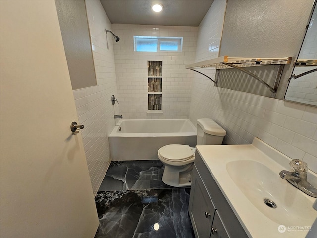 full bath featuring marble finish floor, tile walls, toilet, vanity, and shower / tub combination