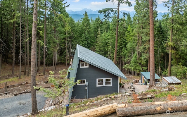 view of side of property featuring a mountain view and an outbuilding