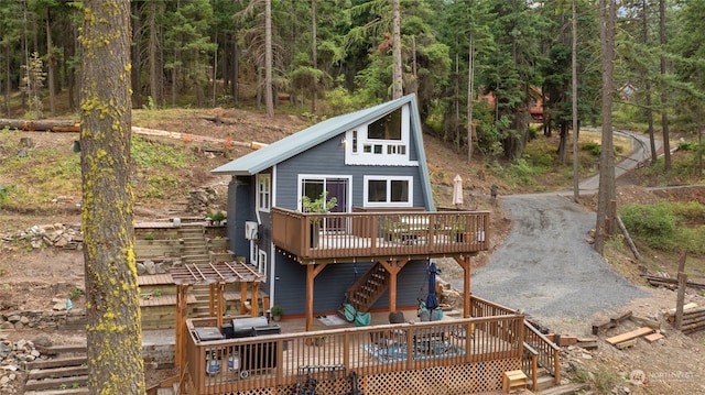 rear view of property with a pergola and a deck