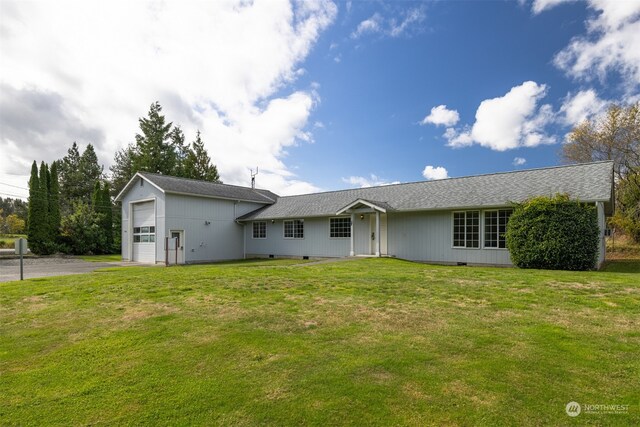 ranch-style home featuring a garage and a front lawn