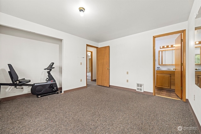 unfurnished bedroom featuring ensuite bath and carpet