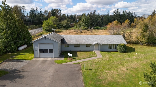 ranch-style house featuring a garage and a front lawn