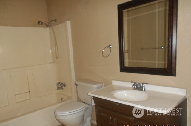 full bathroom featuring washtub / shower combination, toilet, and vanity