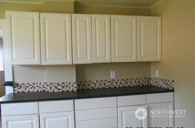 kitchen with crown molding and white cabinetry