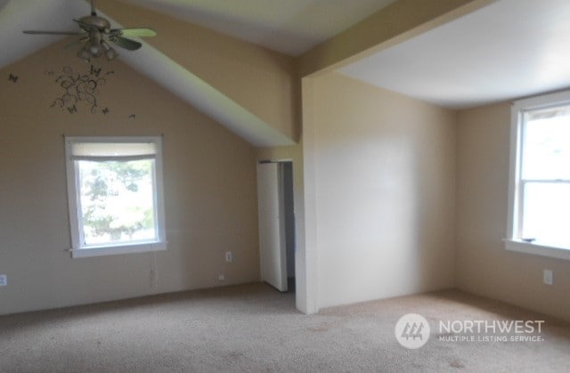 interior space with ceiling fan, light carpet, and lofted ceiling with beams