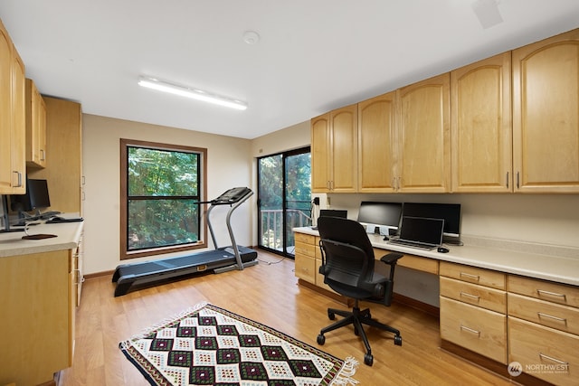 office featuring built in desk and light hardwood / wood-style floors