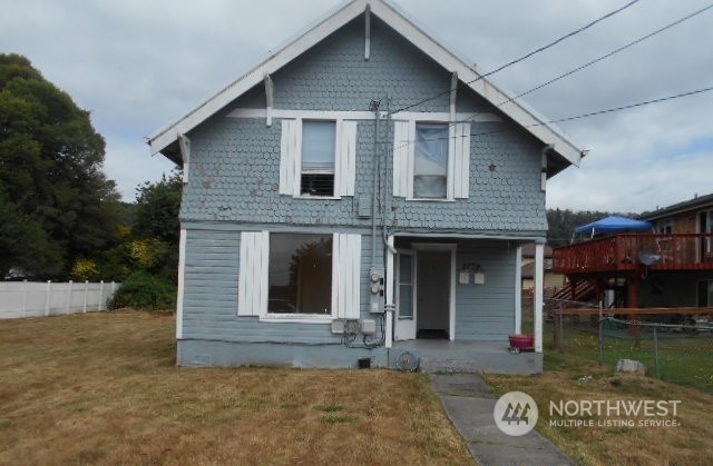 view of front of home with a front lawn and a wooden deck