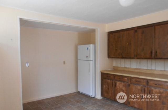 kitchen featuring freestanding refrigerator and light countertops