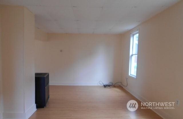 spare room featuring light wood-style flooring and baseboards