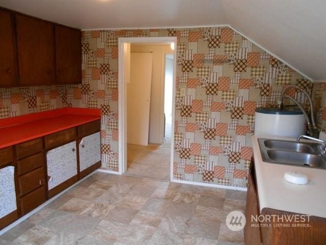 kitchen with vaulted ceiling and a sink