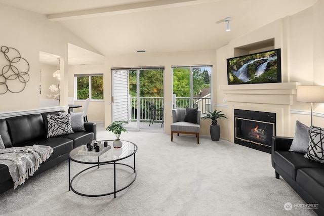 living room featuring a healthy amount of sunlight, carpet flooring, and vaulted ceiling with beams