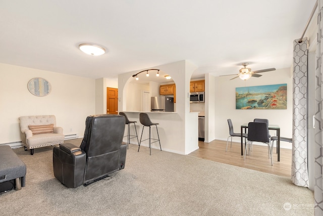 sitting room featuring ceiling fan, light hardwood / wood-style flooring, and baseboard heating