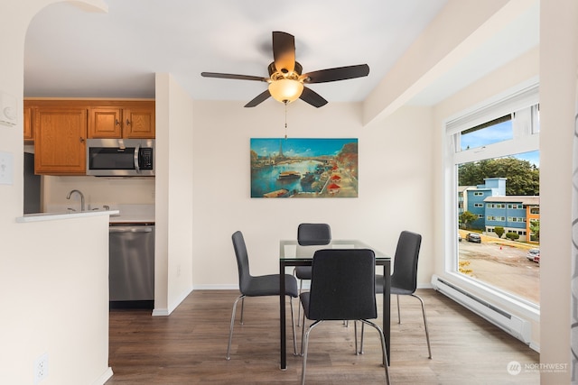 dining room with ceiling fan, hardwood / wood-style floors, and a baseboard heating unit