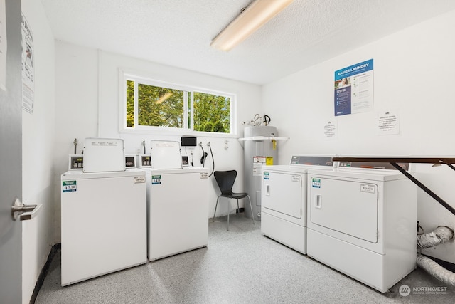 laundry room with a textured ceiling, washer and clothes dryer, and water heater