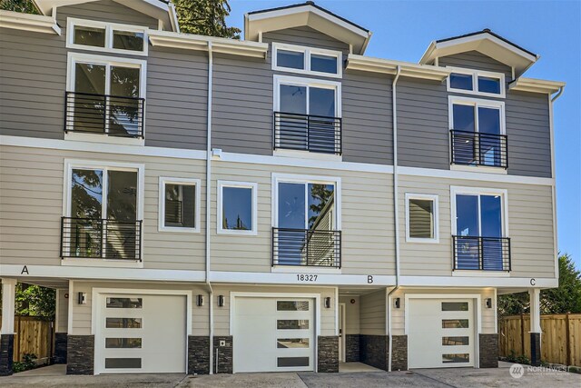 townhome / multi-family property featuring a balcony and a garage