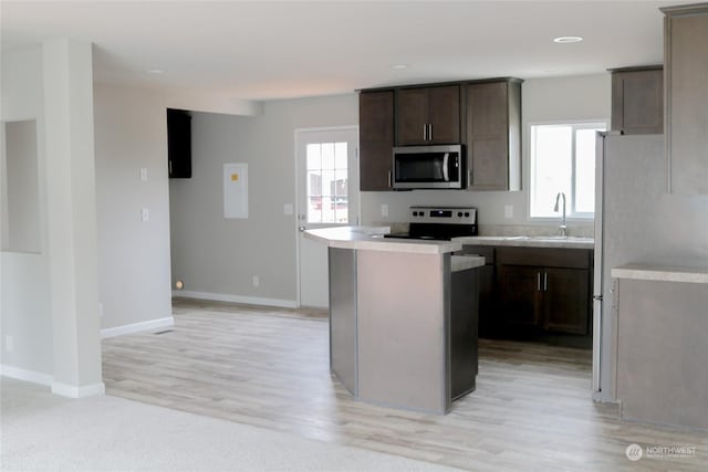 1400 Samuel Dr, Walla Walla, WA 99362 - kitchen with a sink, dark brown cabinetry, light countertops, appliances with stainless steel finishes, and a kitchen island