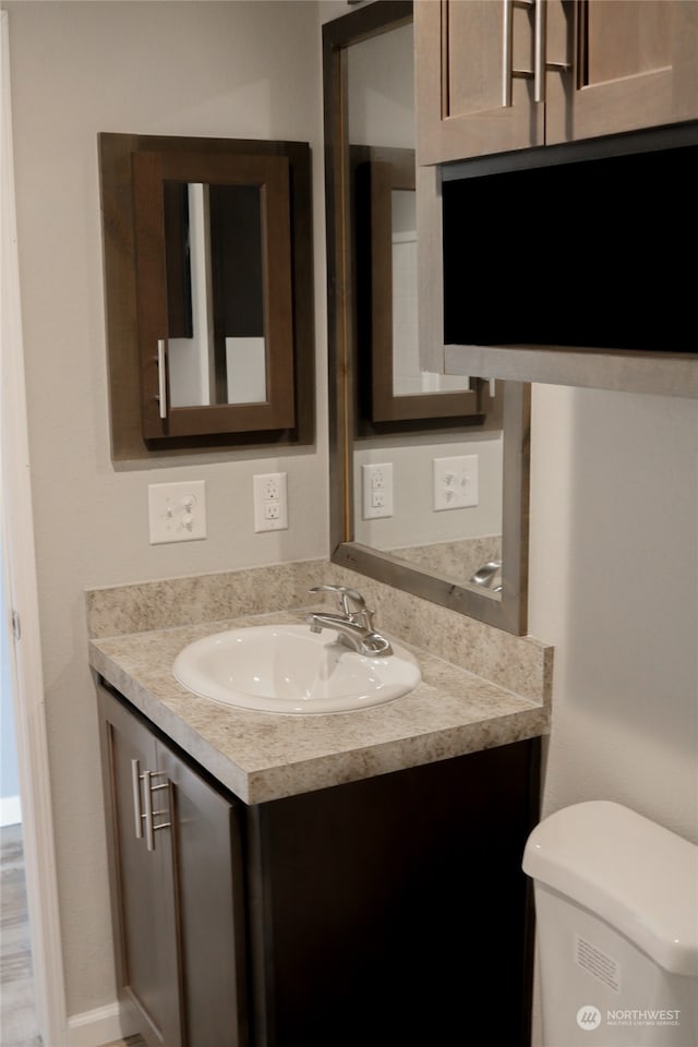 bathroom featuring vanity and toilet